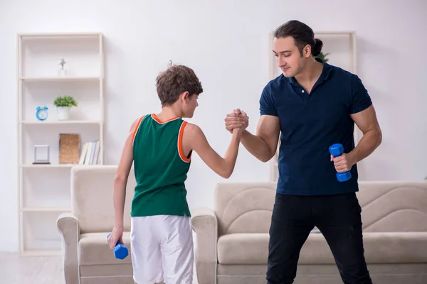 Father and son doing sport exercises indoors