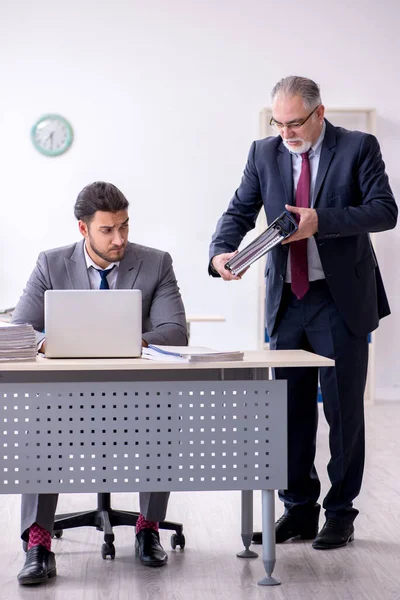 Velho chefe e seu jovem assistente trabalhando no escritório — Fotografia de Stock