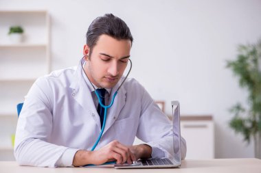 Steteskopu tamir eden genç bir erkek doktor.