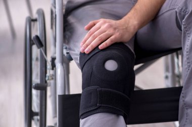 Tekerlekli sandalyedeki yaralı genç adam.