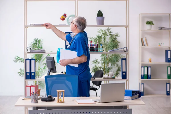 Oude mannelijke arts werkzaam in de kliniek — Stockfoto