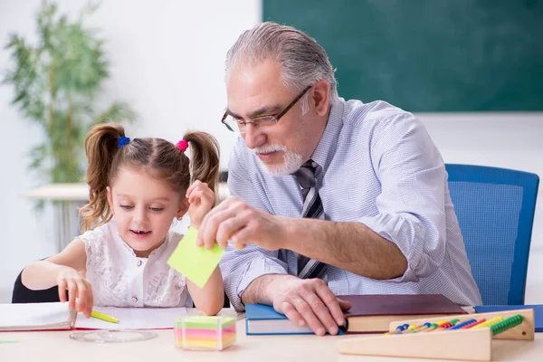 Oude leraar en schoolmeisje op school — Stockfoto