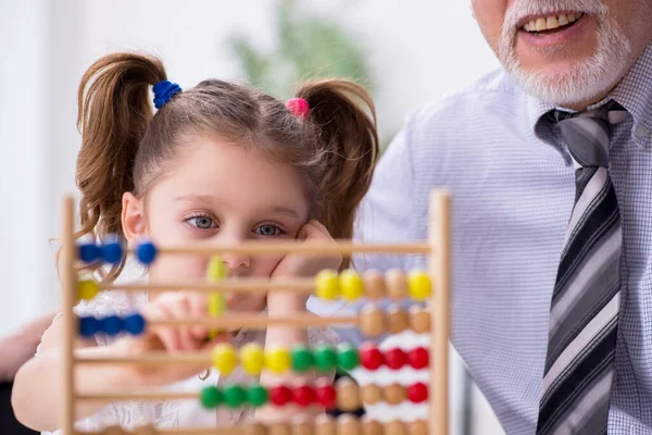 Oude leraar en schoolmeisje op school — Stockfoto