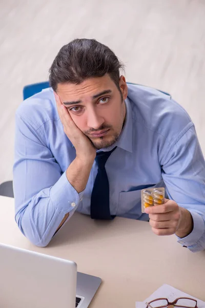 Zieke mannelijke werknemer die op het werk lijdt — Stockfoto