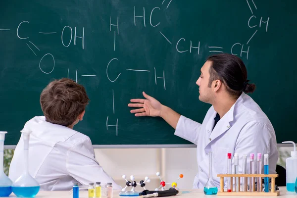 Joven profesor de química y colegial en el aula —  Fotos de Stock