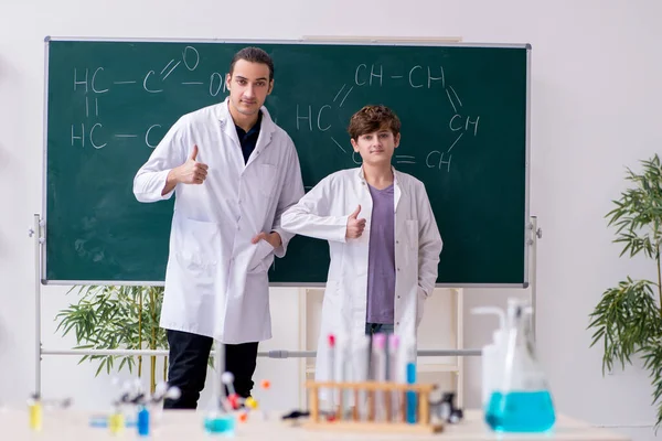 Mladý učitel chemie a školák ve třídě — Stock fotografie