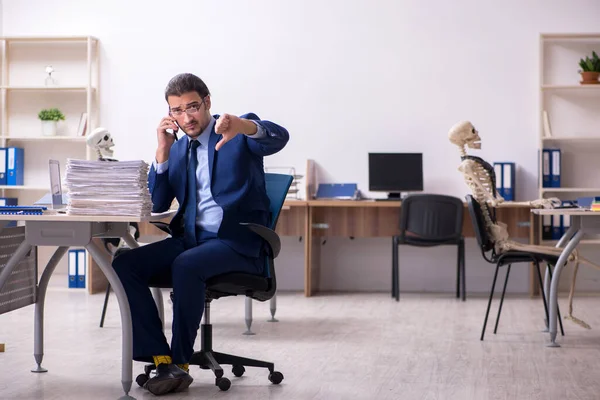 オフィスで骨格を持つ若い男性従業員 — ストック写真