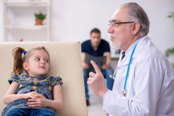 Genç baba ve kızı yaşlı doktoru ziyaret ediyor. — Stok fotoğraf