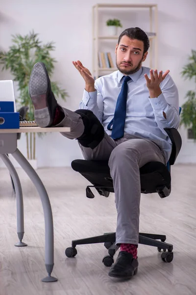 Young leg injured employee working in the office — Stock Photo, Image