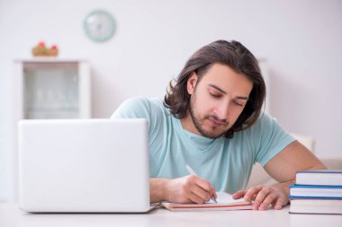 Genç bacak yaralı öğrenci evde çalışıyor.