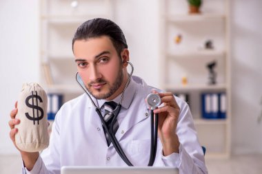 Klinikte çalışan genç erkek doktor.