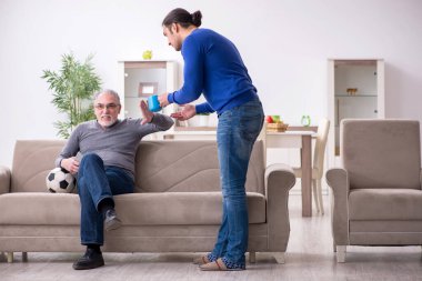 Baba oğul televizyonda maç izliyorlar.