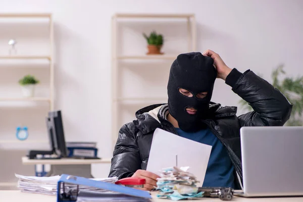 Junger männlicher Einbrecher im Büro — Stockfoto