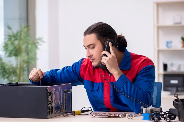 Jovem reparador do sexo masculino reparando computador — Fotografia de Stock