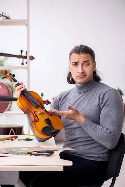 Giovane riparatore di sesso maschile riparazione violino — Foto Stock