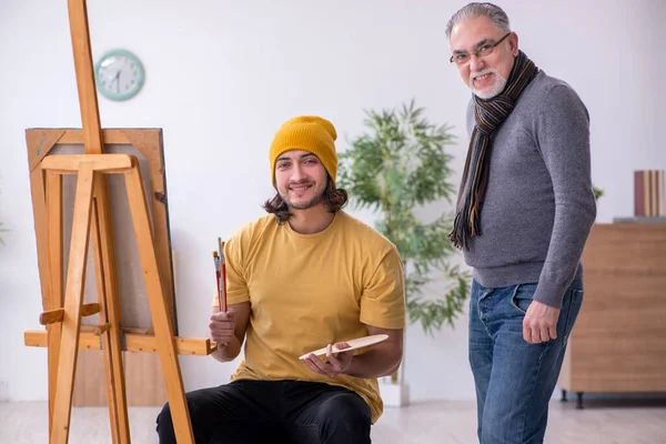 Joven tomando lecciones del viejo pintor — Foto de Stock