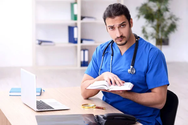 Jovem médico do sexo masculino trabalhando na clínica — Fotografia de Stock