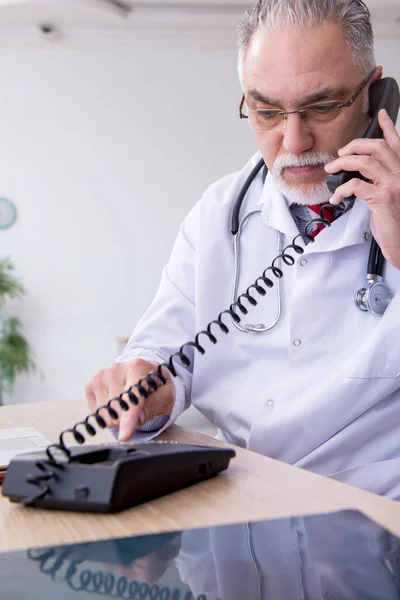 Klinikte çalışan yaşlı erkek doktor. — Stok fotoğraf