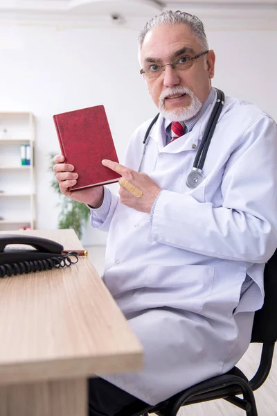 Klinikte çalışan yaşlı erkek doktor. — Stok fotoğraf