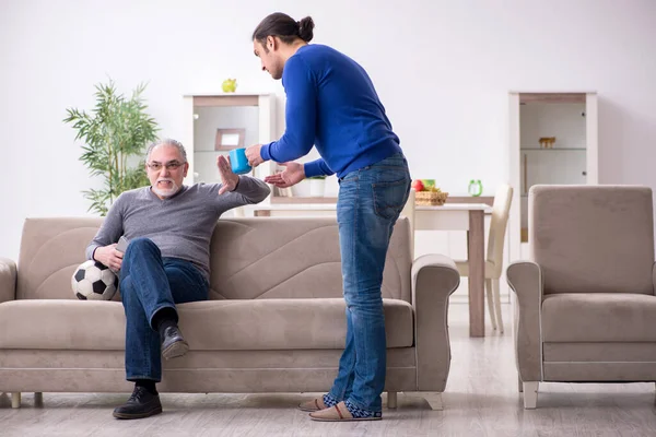 Baba oğul televizyonda maç izliyorlar.