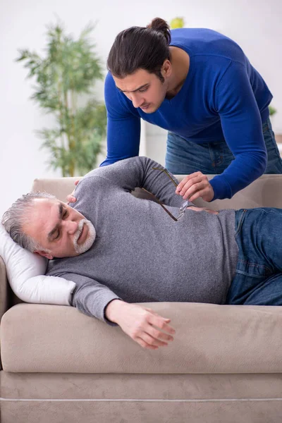 Молодий чоловік піклується про свого хворого батька — стокове фото