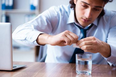 Hasta erkek çalışan ofiste acı çekiyor.