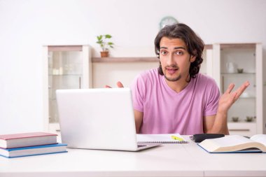 Evde sınava hazırlanan genç bir erkek öğrenci.