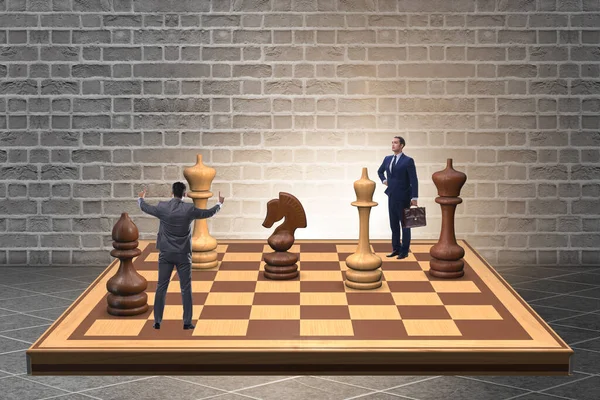 Бизнесмен в большой шахматной доске в концепции стратегии — стоковое фото