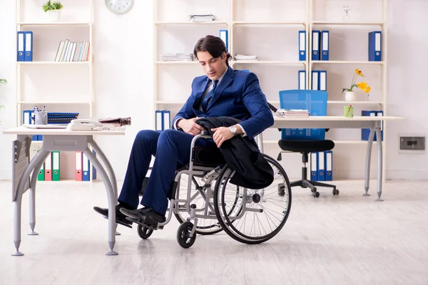 Young male employee in wheelchair working in the office