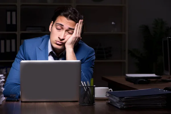 Ung manlig anställd som arbetar natt på kontoret — Stockfoto