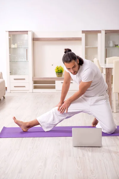 Young man doing physical exercises at home — Stock Photo, Image