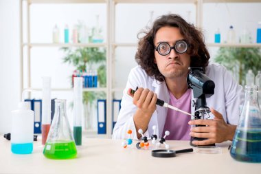 Laboratuvarda çalışan komik erkek kimyager.