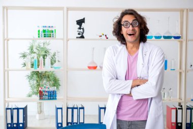 Laboratuvarda çalışan komik erkek kimyager.