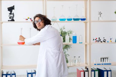 Laboratuvarda çalışan komik erkek kimyager.