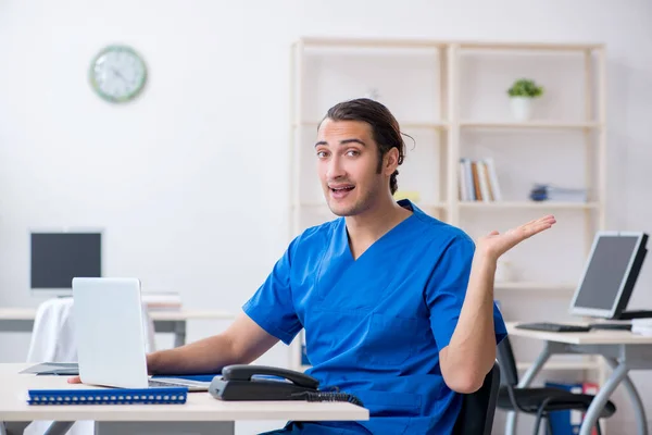 Jonge mannelijke arts werkzaam in de kliniek — Stockfoto