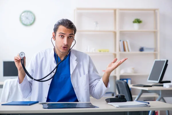 Jonge mannelijke arts werkzaam in de kliniek — Stockfoto