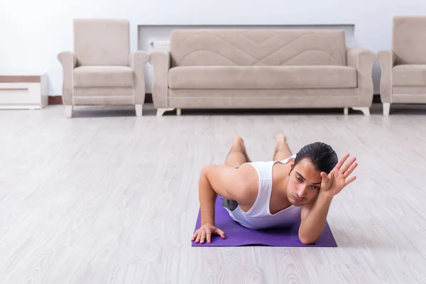 Jovem treinando e exercitando em casa — Fotografia de Stock