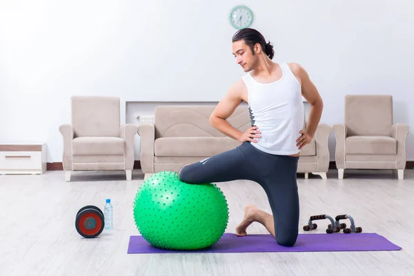 Jovem treinando e exercitando em casa — Fotografia de Stock