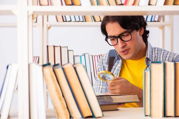 Männlicher Student bereitet sich in Bibliothek auf Prüfungen vor — Stockfoto