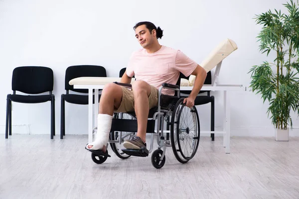 Mladý zraněný muž čeká, až bude na řadě v nemocniční hale — Stock fotografie