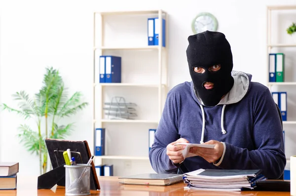 Männlicher Dieb mit Sturmhaube im Büro — Stockfoto