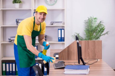 Genç müteahhit ofisi temizliyor.