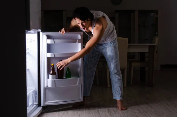 Man bryter diet på natten nära kylskåp — Stockfoto