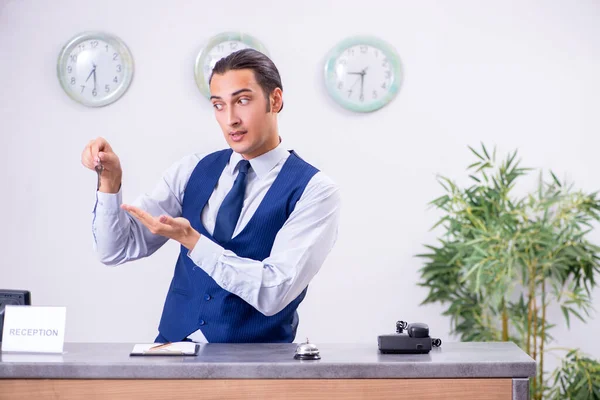 Young man receptionist at the hotel counter