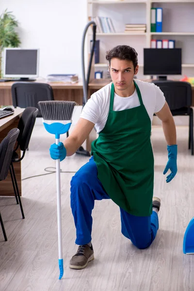Young handsome contractor cleaning the office — Stock Photo, Image