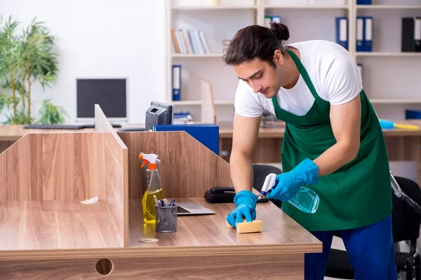 Jonge knappe aannemer schoonmaken van het kantoor — Stockfoto