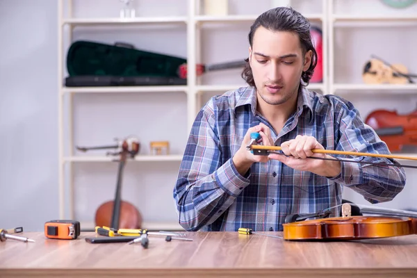 Joven reparador guapo reparando violín —  Fotos de Stock