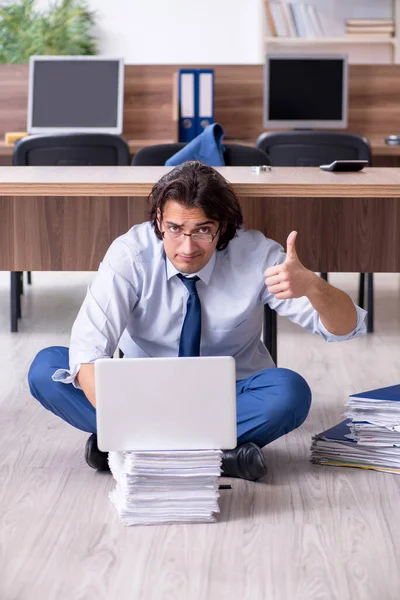 Young male employee and too many work in the office — Stock Photo, Image