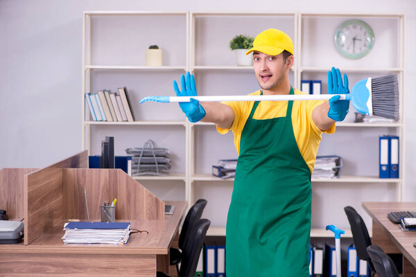 Молодой мужчина-подрядчик убирает офис