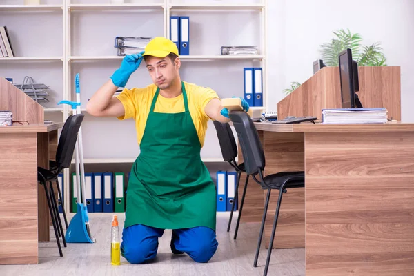 Jonge mannelijke aannemer schoonmaken van het kantoor — Stockfoto